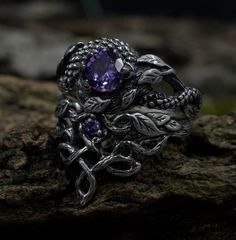 Handcrafted for enchanting souls, our ethereal fairy witchy wedding ring set embodies mystical allure and magical elegance. Crafted from sterling silver, it features intricate details inspired by celtic fantasy, including delicate branches and leaves, complemented by a striking dragon motif. The enchanting purple hue adds a touch of magic to this silver witches knot jewelry, making it a perfect choice for those seeking a unique and mystical accessory set for their special day. Characteristics: Metal - Recycled solid sterling silver  Stone - Cubic Zirconia Finish - Oxidized. View all silver dragon rings: https://www.etsy.com/shop/TinyShinyJewel?ref=seller-platform-mcnav&section_id=45210616 Care instructions: To care for the ring, avoid contact with water and chemicals such as perfumes and l Magical Silver Crystal Promise Ring, Silver Magical Crystal Promise Ring, Mystical Silver Jewelry With Intricate Design, Mystical Silver Crystal Ring For Anniversary, Silver Mystical Crystal Ring For Anniversary, Mystical Style Silver Promise Ring, Mystical Silver Promise Ring, Magical Silver Crystal Ring For Anniversary, Handmade Magical Silver Crystal Ring