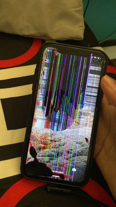 someone is holding their cell phone with colorful lines on the screen