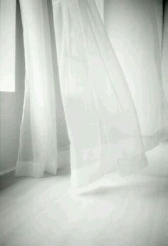 a black and white photo of curtains in a room