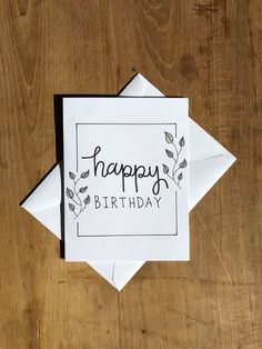 a card with the words happy birthday written on it, sitting on top of a wooden table