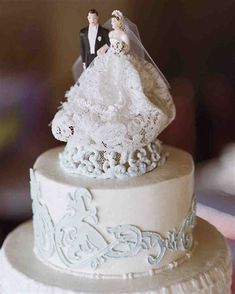 a wedding cake with a bride and groom figurine on top