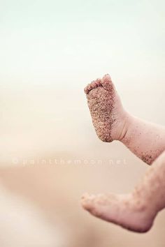 a person's foot covered in sand on the beach