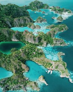 an aerial view of several small islands in the ocean with blue water and green vegetation