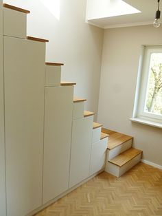 an empty room with stairs leading up to the window