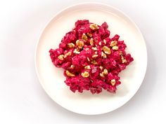 a white plate topped with beets and nuts