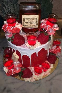 a cake with strawberries and jam on top is sitting on a table next to candles