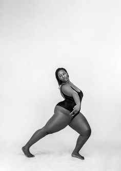 a black and white photo of a woman in a bathing suit posing for the camera