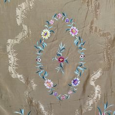 an embroidered fabric with flowers and leaves on the side, in various shades of brown