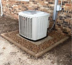 an air conditioner sitting in front of a brick building