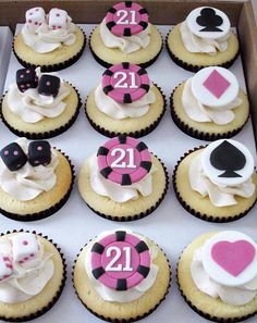 cupcakes decorated with pink, black and white icing are in a box