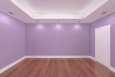 an empty room with purple walls and wooden floors