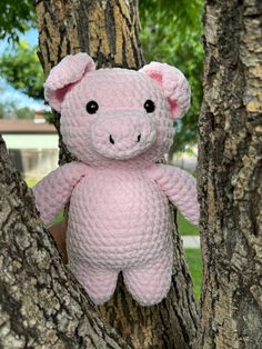 a pink crocheted teddy bear in a tree