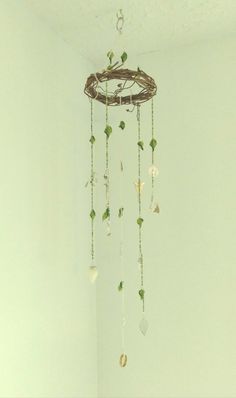 a wind chime hanging from the ceiling in a room with white walls and flooring