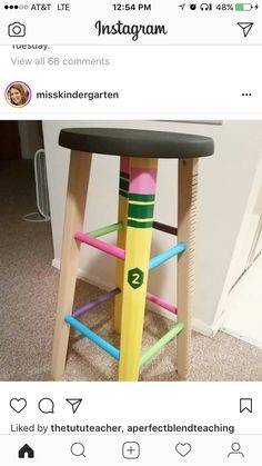 a wooden stool made out of colored pencils on top of carpeted flooring