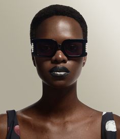 Our Judy sunglasses with a shiny, solid black frame feature a statement rectangular silhouette, engraved with miniature orb motifs at the temples. The design incorporates jewellery-inspired pearl detailing, which has become a signature style of the brand, having appeared in many collections throughout the house's history. Luxury Rectangular Sunglasses For Evening, Elegant Square Frame Sunglasses For Party, Elegant Rectangular Sunglasses For Formal Occasions, Luxury Rectangular Sunglasses For Party, Elegant Rectangular Sunglasses For Party, Elegant Square Sunglasses, Elegant Rectangular Party Sunglasses, Black Vivienne Westwood, Vivienne Westwood