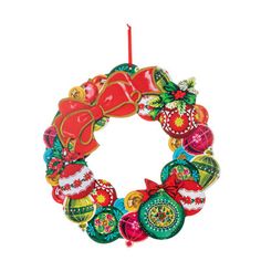 a christmas wreath ornament hanging on a white wall with a red candle in the center