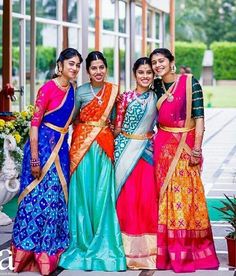 three women standing next to each other in colorful dresses