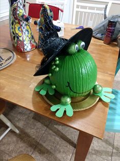 a table topped with a green cake covered in frosted icing and witches hats