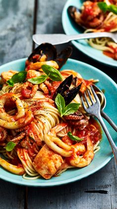 two plates of pasta with meat and sauce on them, one has a fork in it