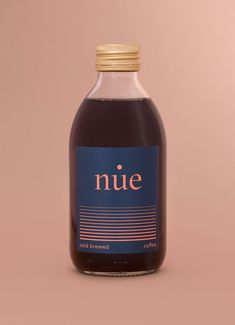 a bottle of nive cold brew coffee on a pink background with a gold cap