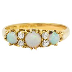 an opal and diamond three stone ring in yellow gold, set with five diamonds