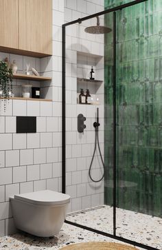 a white toilet sitting inside of a bathroom next to a walk in shower and green tiled walls