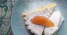 a piece of cake with powdered sugar on top and an orange slice in the middle