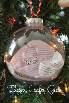 a baby's first christmas ornament hanging from a christmas tree