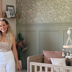 a woman standing next to a baby crib