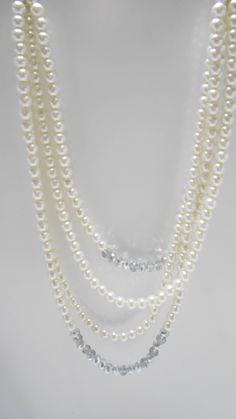 "Gorgeous vintage faux pearl necklace. Four strands of 8mm faux pearls & crystals. The end strands consist of two 6\" strands of rhinestone rondelles, silver tone bead spacers, various mm sizes of faux pearls and a crystal. The faux pearl graduating strands are 15\" - 21\" long. Lobster claw fastener. This is a very heavy necklace. Excellent condition. Unsigned." Elegant Beaded Rhinestone Necklace With Round Beads, Formal Beaded Pearl Rhinestone Necklace, Classic Multi-strand Pearl Necklace For Party, Formal Pearl Necklace With Rhinestones, Heavy Necklace, Funky Necklace, Sweater Clip, Faux Pearl Necklace, Glass Bead Necklace