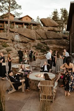 a group of people sitting around a fire pit in the middle of a patio area