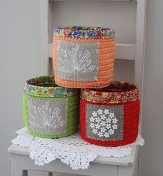 three crocheted baskets sitting on top of a white chair