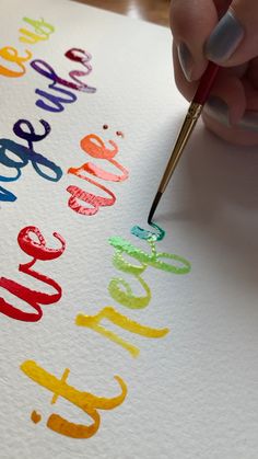 a woman's hand writing on paper with a red marker