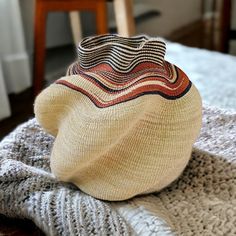 a hat sitting on top of a bed next to a chair