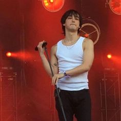 a male in a white shirt and black pants on stage