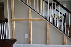 an empty living room with white walls and wood trimmings on the stair case