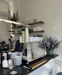 a kitchen counter topped with lots of plates and cups