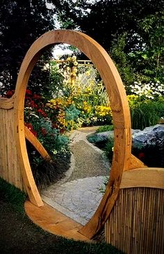 a wooden arch in the middle of a garden