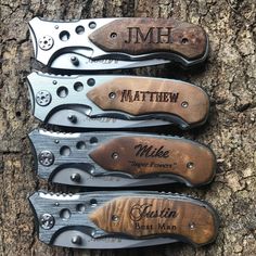 three different types of knifes sitting on top of a wooden tree trunk with names engraved on them