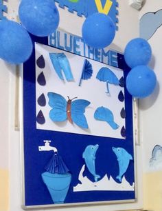 some blue balloons are hanging from the ceiling in front of a sign that says blue theme