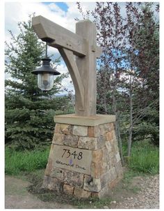 a wooden cross sitting on top of a stone pillar