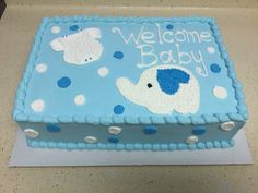 a baby shower cake with blue and white icing on it's side, featuring an elephant