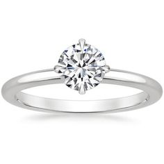 a white gold engagement ring with a round brilliant diamond in the center, on a plain band