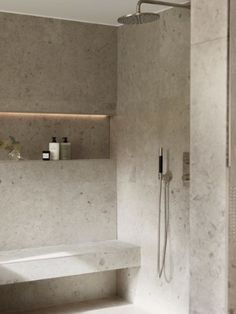 a bathroom with a tub, shower head and shelves