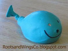 a blue stuffed fish sitting on top of a wooden table