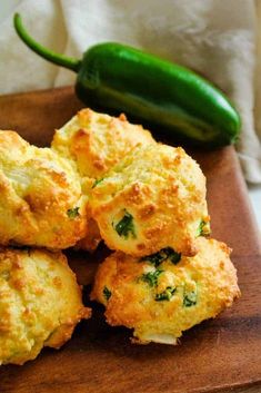 some food is sitting on a cutting board next to a green pepper and a white towel