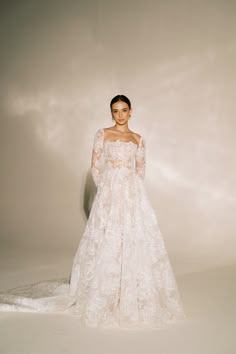 a woman in a white wedding dress with long sleeves