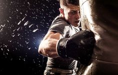 a man with boxing gloves on is punching a punching bag in front of a dark background