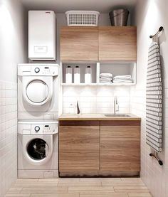 a washer, dryer and cabinets in a small room with tile flooring