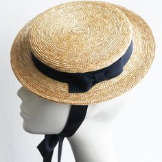 Mimi Edwardian Straw Canotier. Crafted in premium fine grade milan straw braid. A chic, elegant and uncluttered stylish hat trimmed with dark navy pure silk ribbon necktie. Mimi canotier is professionally finished with a steel wired brim edge for structure and stability. This attention to detail and finishing adds everlasting quality. The hat is set in place on the head with adjustable millinery elastic and/or long pure silk neckties.  SHIPPING All shipments will be sent via DHL All Worldwide pa Elegant Adjustable Toquilla Straw Hat, Natural Summer Hat For Formal Occasions, Elegant Woven Brimmed Straw Hat, Elegant Fitted Natural Hat Band, Elegant Adjustable Woven Hat Bands, Elegant Woven Brimmed Boater Hat, Elegant Natural Boater Hat With Flat Brim, Elegant Adjustable Woven Boater Hat, Classic Fitted Boater Hat For Garden Party